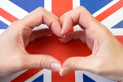 I love England. Hands make heart on United Kingdom flag background. 7 june British national day