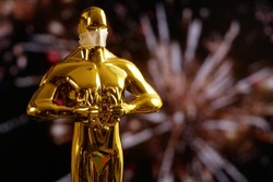Hollywood Golden Oscar Academy award statue on fireworks background with copy space. Success and victory concept.