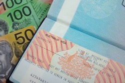 australian visa on an open passport with australian currency bank notes    