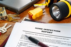 Real estate home inspection report of resale residential property condition with professional housing engineering inspector testing tools and house keys (fictitious but realistic document)
