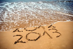 New Year 2013 is coming concept - inscription 2012 and 2013 on a beach sand, the wave is covering digits 2012