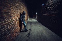 Suspicious man in dark alley waiting for something