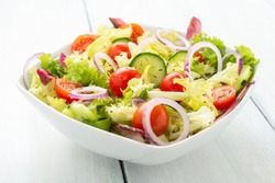 Fresh salad with cucumber, lettuce, tomatoes, onion and thyme 