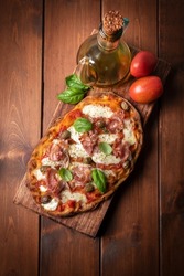 Delicious roman pinsa with mozzarella, tomato sauce and prosciutto, Italian food 