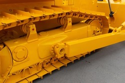 Closeup of heavy caterpillar and basket of a large construction machine