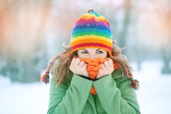 Portrait of a young woman in snow  with scarf on her face trying to warm herself. Winter concept
