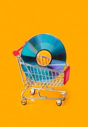 Disk in shopping cart isolated on orange background