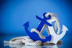 Wooden decorative anchor on the blue background