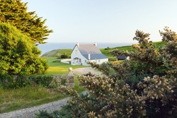 The image of a house at sunset against the coast of Plogof, Bretagne, France.