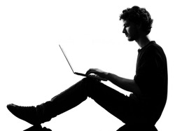 young man silhouette silhouette sitting computing computer laptop in studio isolated on white background