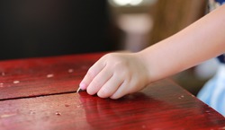 Child hand put a coin in donation box