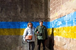 Older couple standing in front of a old wall