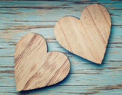 Two wooden hearts placed nicely on a turquoise vintage wood background