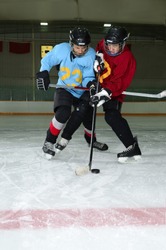 Two Boys play a Winter Hockey Scrimmage in Rink