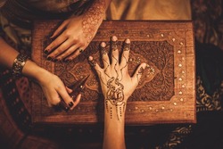 Drawing process of henna menhdi ornament on woman's hand 