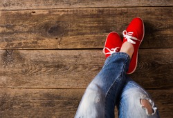 red Sneakers shoes walking on Dirty wooden top view