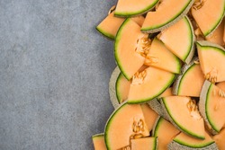 Cantaloupe melon slices, food border background, top view.