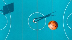Basketball Player, Long Shadows on Basketball Court, Creative Visual Art, Aerial Image.