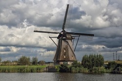 Traditional windmill in a rural landscape under a cloudy Dutch sky in Kinderdijk near Rotterdam, Holland