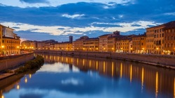 City of Pisa and Arno river at dusk, Italy. Night cityscape