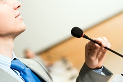 male speaker looks into the room and said into the microphone, speech at the conference