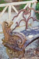 Stone ancient bench with ornate elements. Vintage seat at the garden