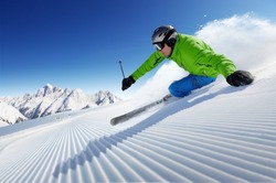 Skier on piste in high mountains with beautiful clear weather and prepared piste