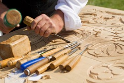 Traditional craftsman carving wood with floral motifs