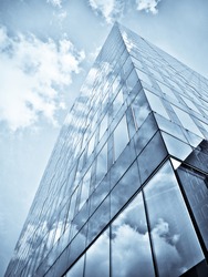 Blue office building with clouds reflection