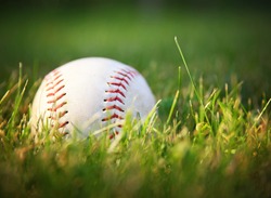 a baseball in a grass during sunset 