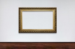 Empty frame on white wall in Museum. place for pictures. Antique Framework. Vintage picture frame on white wall.