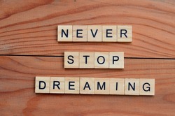 never stop dreaming text on wooden square, motivation and inspiration quotes