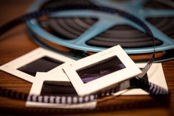Shallow focus background image of 35mm slides and 8mm Super 8 film reel with vintage filter