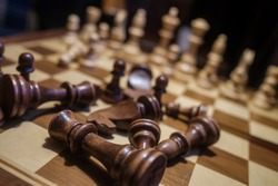 Soft focus of closeup brown pieces lying on board after loss in chess match