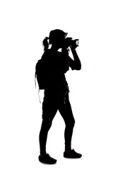 Backlit silhouette of a female photographer hiking and isolated on a white background for composites.  She is holding a camera and posing as a journalist or a hobbyist