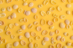 Corn flakes pattern on yellow background, top view