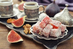 Cup of coffee with turkish delight  and metal oriental tray on wooden background