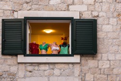 Funny exposition of bras and underclothes in old window with wooden shutters.
