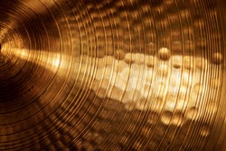 Extreme close-up of an old golden cymbal of drum kit. Percussion instrument