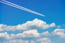 Beautiful storm clouds, cumulus clouds or cumulonimbus against a clear blue sky with an airliner with contrails. Photography, Full frame.