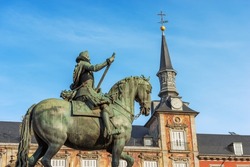 Bronze statue of King Philip III on Horseback in Plaza Mayor (main square), and the Casa De La Panaderia (house of the bakery, 1619), ancient palace in Madrid downtown, Spain, southern Europe.