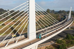 A Sydney Metro train crossing a bridge over Windsor Rd, Rouse Hill, Australia.