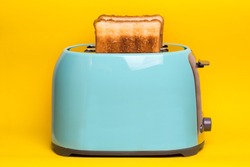 bright, fun breakfast. cyan color toaster on a yellow background