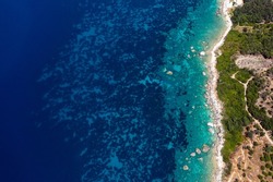 Aerial top view of turquoise sea waves and fantastic rocky coastline
