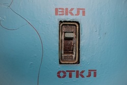 A black 380 volt three-phase circuit breaker switch in a blue switchboard labeled 
