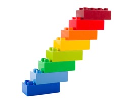 A rainbow color lego blocks in the form of stairs on white background
