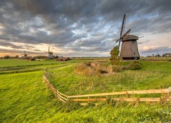 Three Traditional wooden windmills in old agricultural landscape near Schermerhorn, North Holland. Netherlands