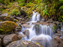 Small Rainforest waterfall long exposure image in lush tropical forest