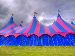 Big top circus tent on a field with brooding sky