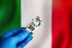 third dose vaccine for Covid-19 for booster shot in the risk population diseases in Italy. Doctor with a vial with 3rd dose of the vaccine for covid-19 or Coronavirus in front of the Italian flag